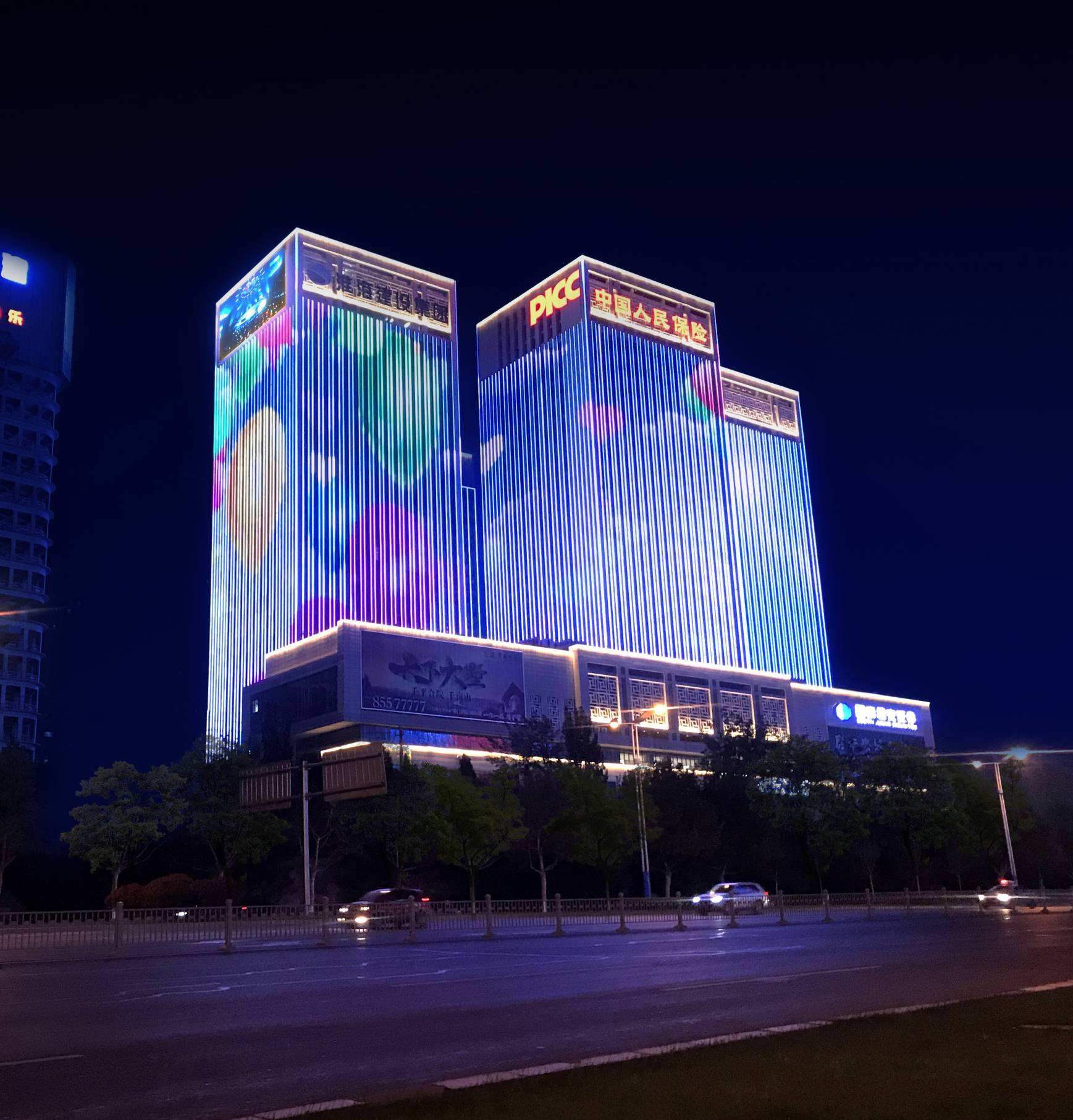 Building facade illuminated with vertical blue and purple lighting at night